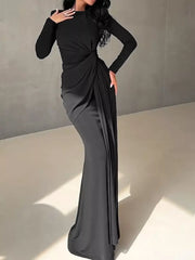 Black ruched long sleeve maxi dress with draped detail and boat neckline.