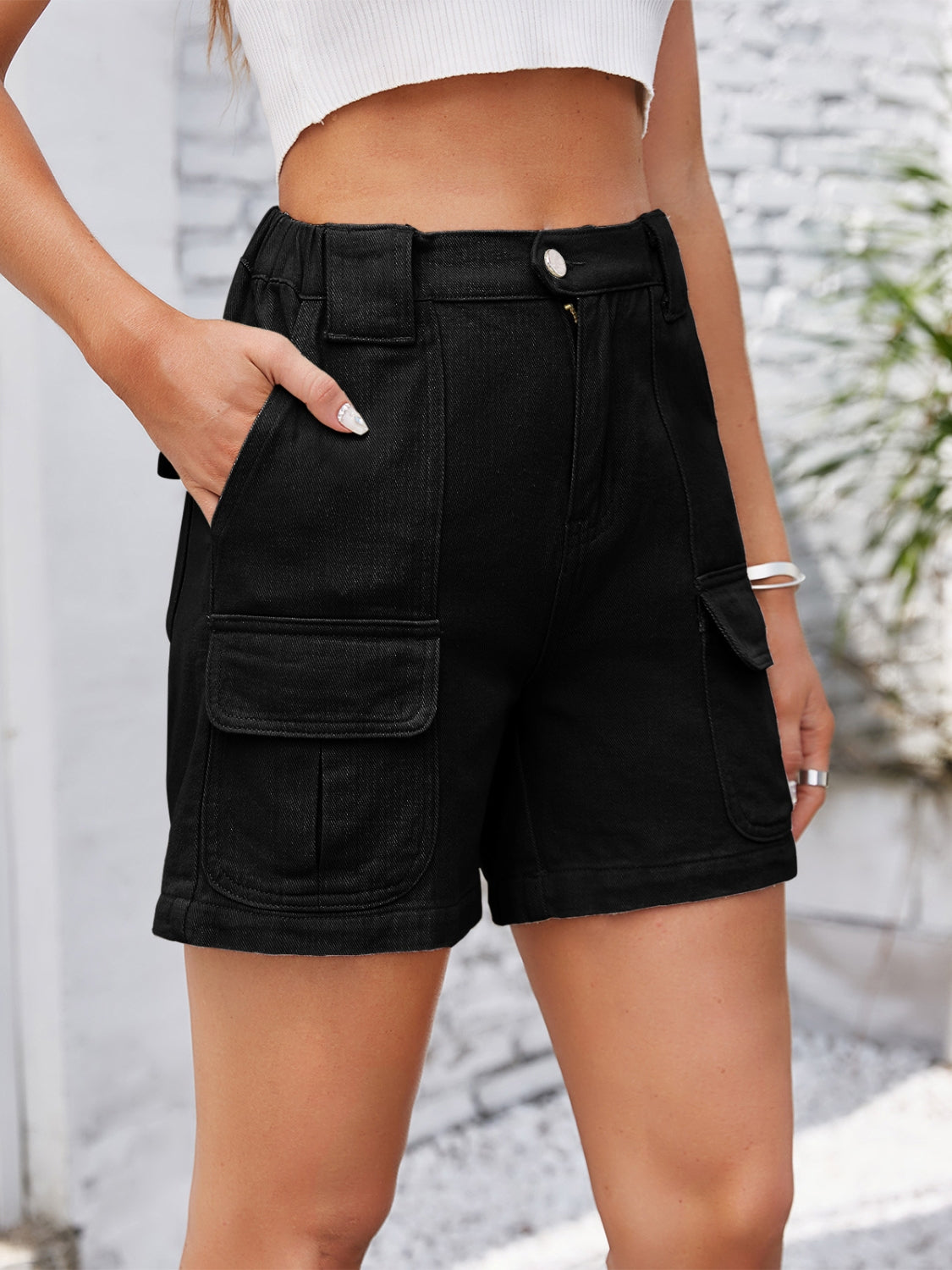 Black denim cargo shorts with high waist and utility pockets.