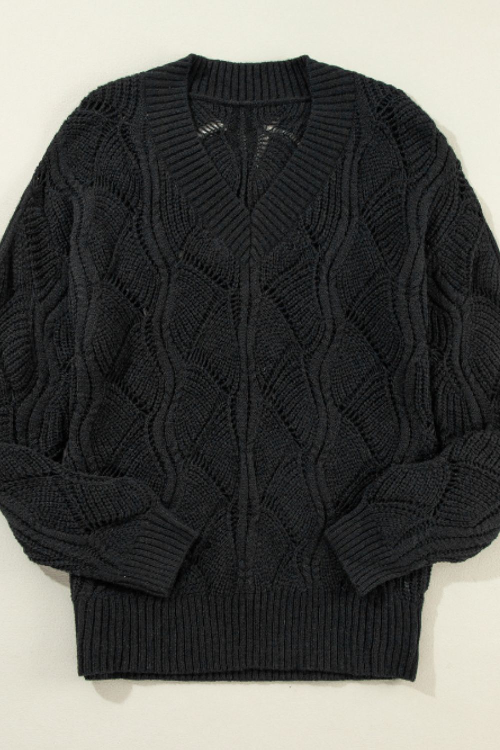 Black openwork knit V-neck pullover sweater with diamond pattern detail.
