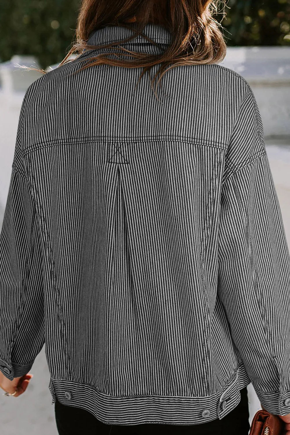 Dark pinstripe denim trucker jacket with back pleat detail and button cuffs.
