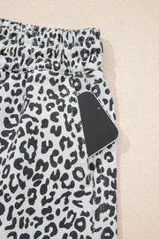 Denim skort with black and white leopard print, elastic waist, and functional pockets.