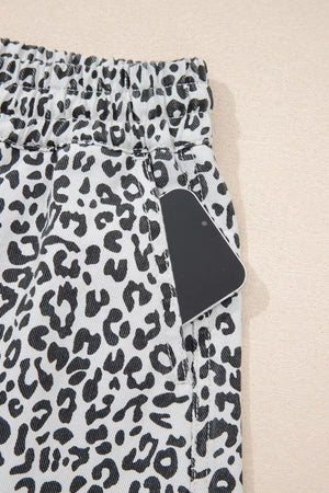 Denim skort with black and white leopard print, elastic waist, and functional pockets.
