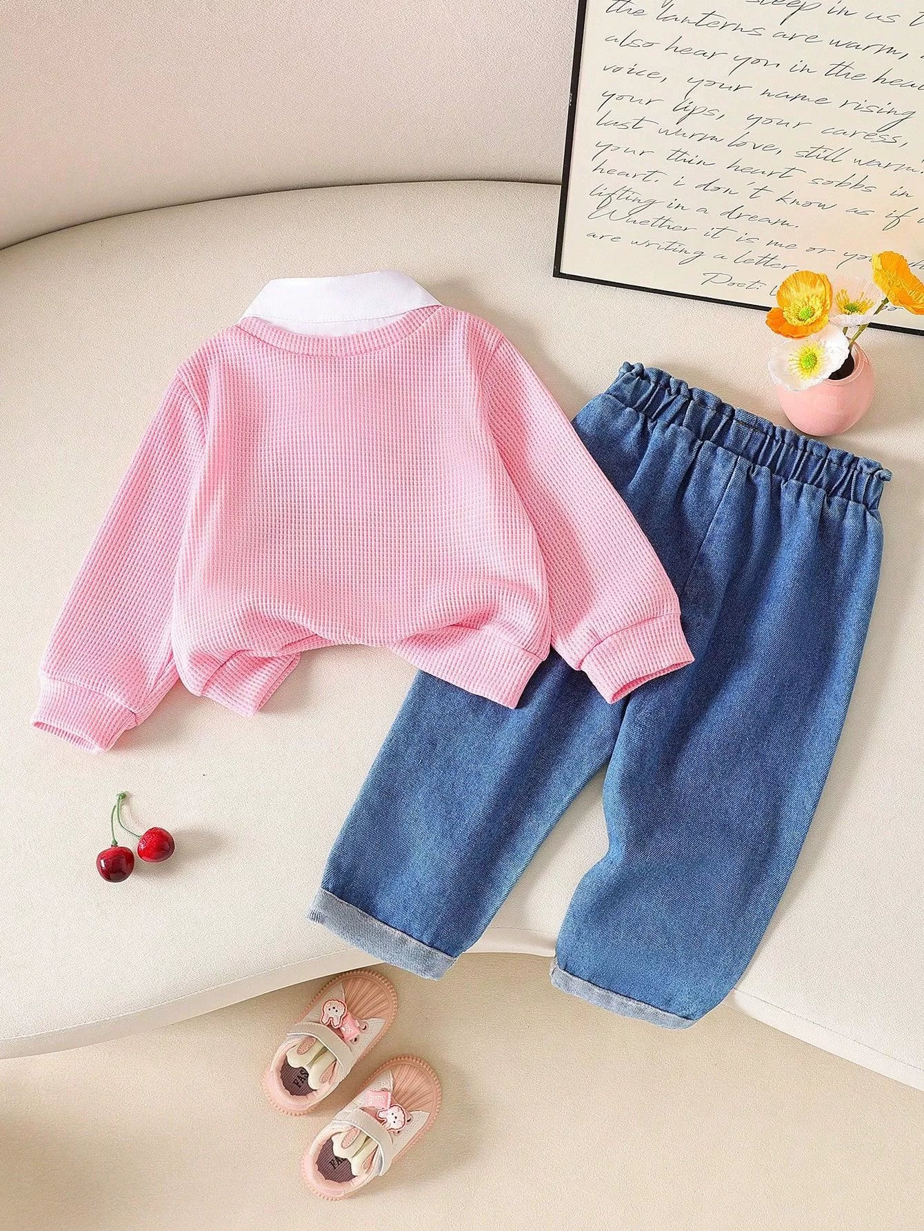 Pink baby set with waffle knit top and white collar, paired with denim pants.