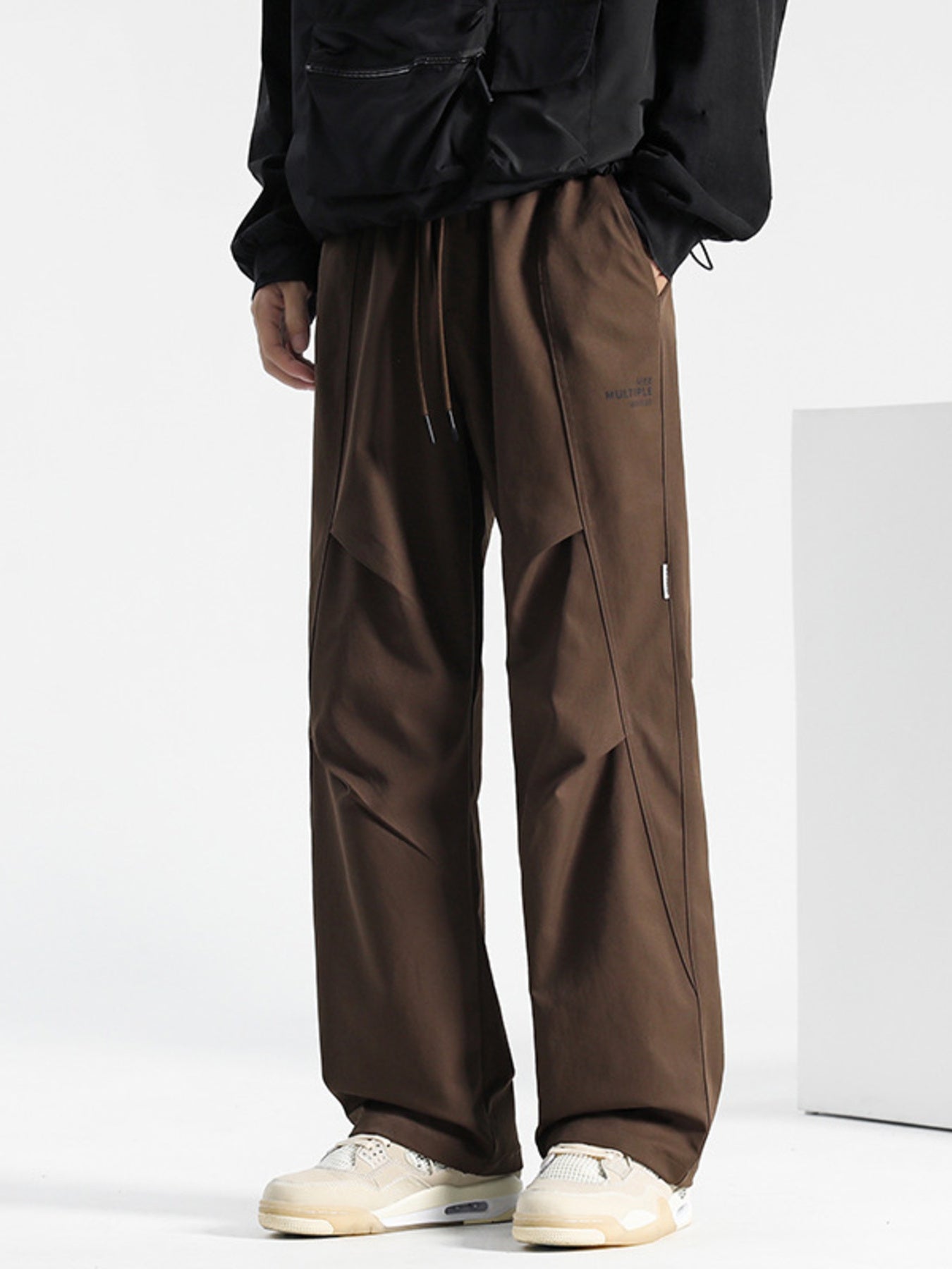 Brown drawstring sweatpants with panel detailing and subtle logo.