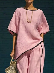Pink two-piece set with contrast trim, cropped pants, and loose top.