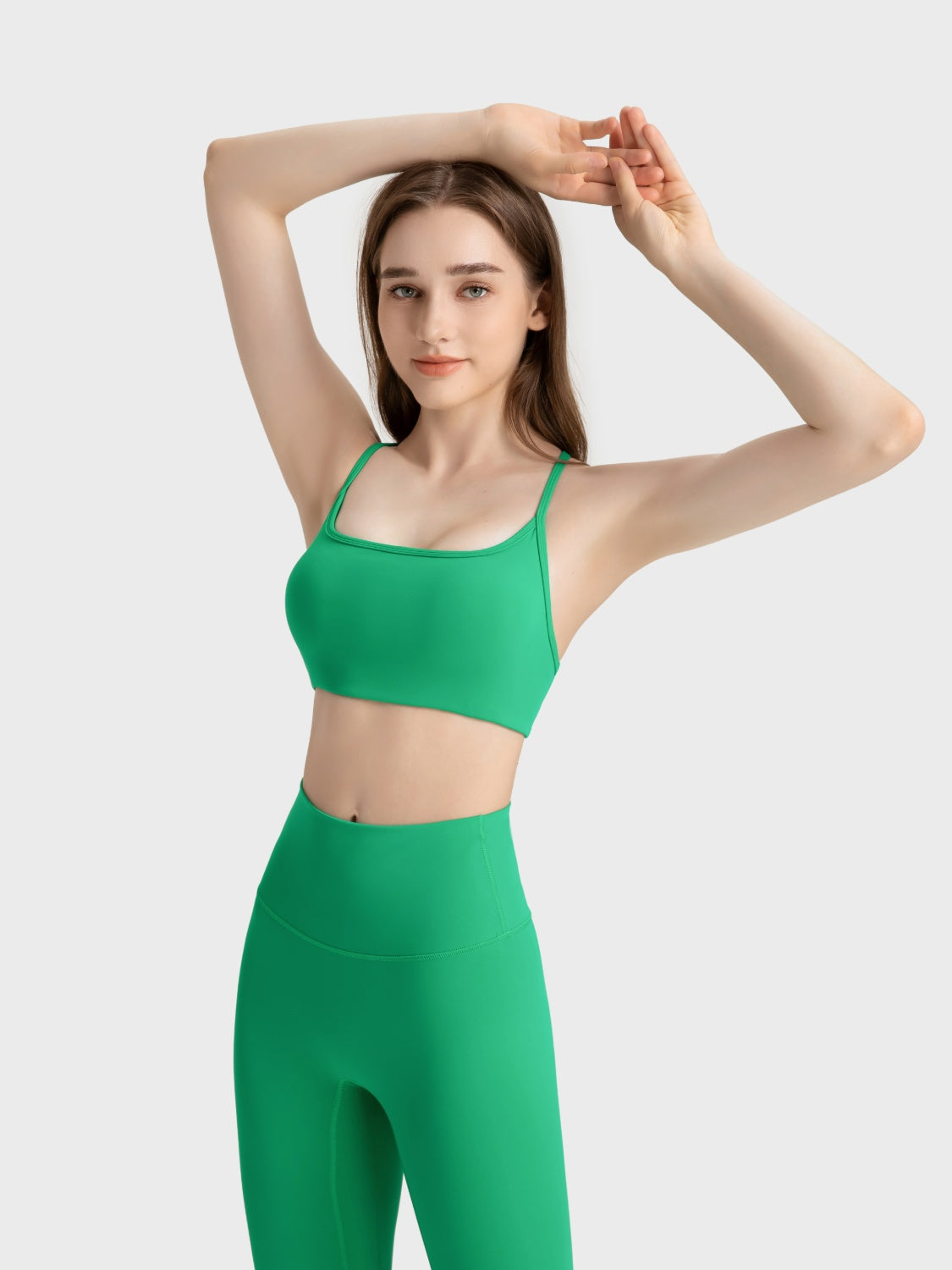 Green active crop top with square neckline and thin straps, paired with matching leggings.