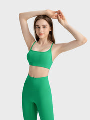 Green active crop top with square neckline and thin straps, paired with matching leggings.