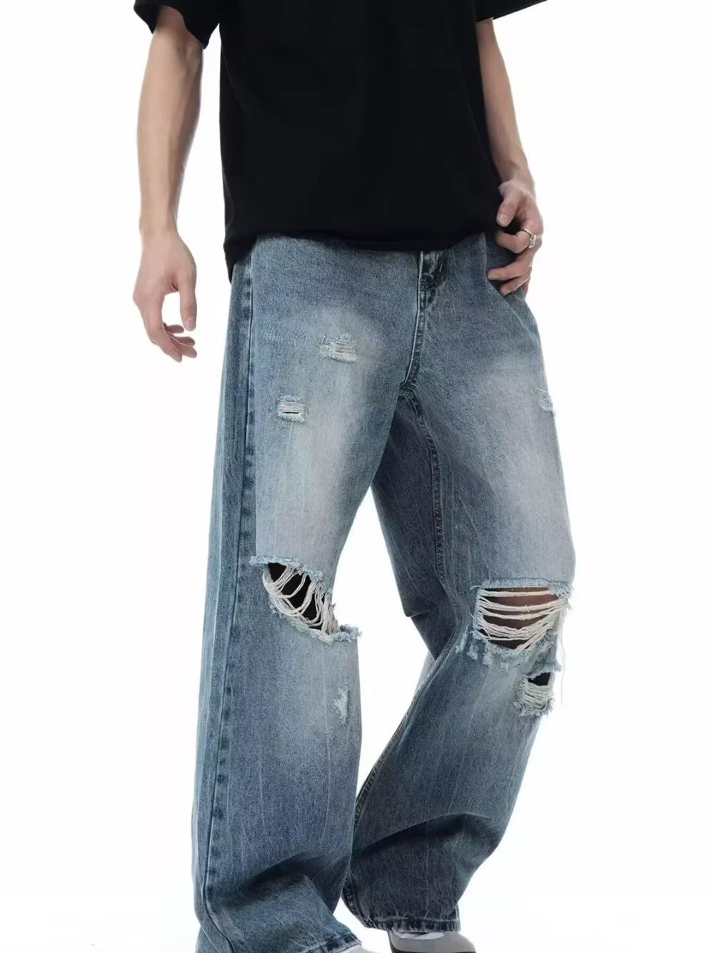 Men's blue distressed wide-leg jeans with ripped knees and casual fit.