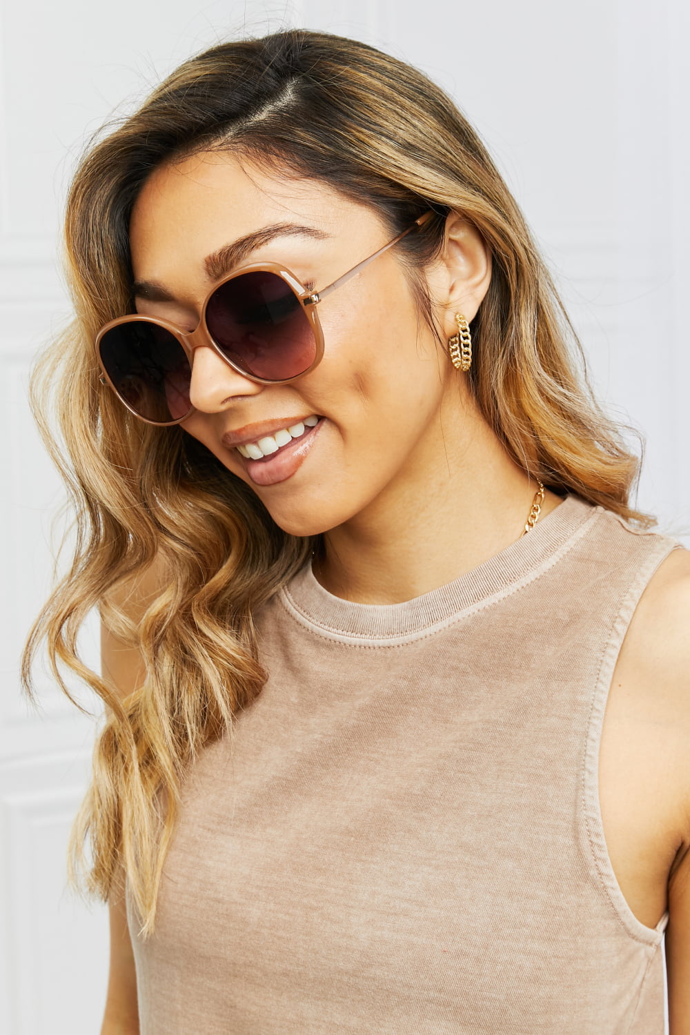 Oversized round frame sunglasses in caramel with gradient lenses, worn by a model.