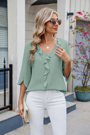 Sage V-neck flutter sleeve blouse with ruffled front detail.