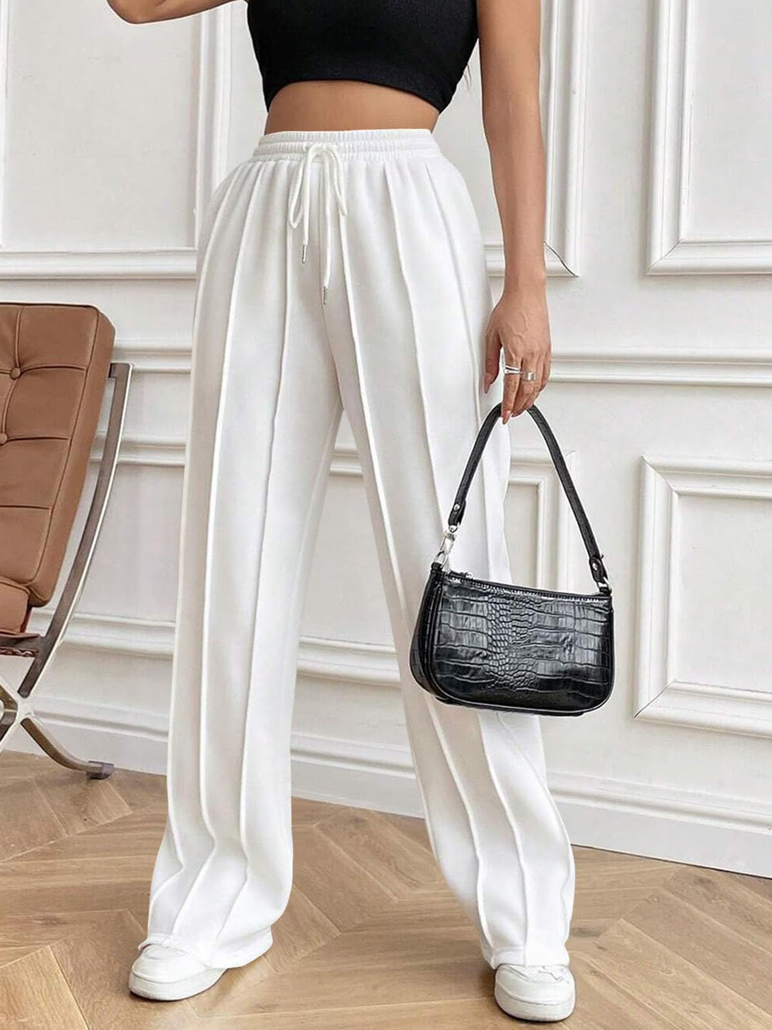 White pleated palazzo drawstring trousers with a wide leg and a casual fit.