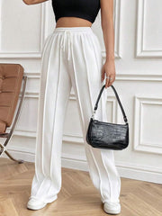 White pleated palazzo drawstring trousers with a wide leg and a casual fit.