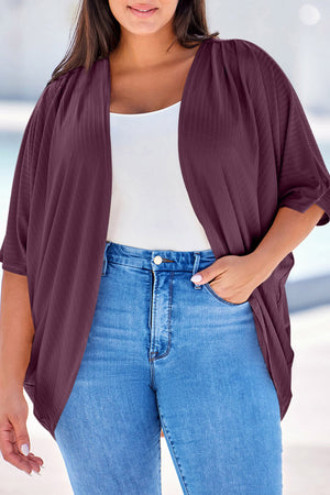 Deep purple ribbed batwing cardigan with draped front, worn over a white tank and jeans.