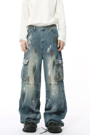 Artisan denim cargo pants in medium wash with paint splatters and wide legs.