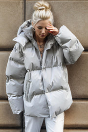 Light gray oversized puffer jacket with hood and zipper detail.