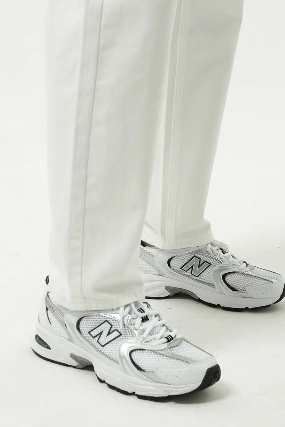 Relaxed fit ivory denim trousers with a straight leg, styled with white sneakers.