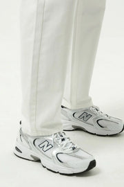 Relaxed fit ivory denim trousers with a straight leg, styled with white sneakers.