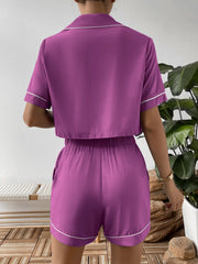 Red-violet pajama set with contrast trim, cropped short sleeve top and elastic waist shorts.