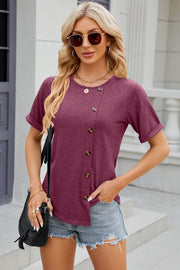 Burgundy asymmetric button-up tee with short sleeves and a round neckline.