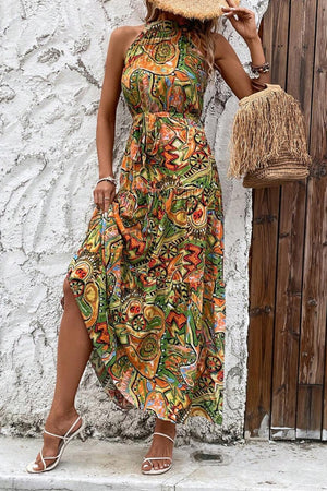 Halter neck maxi dress with a colorful paisley print, belted waist, and tiered skirt.