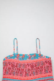 Smocked floral maxi dress with spaghetti straps and a ruffled neckline in pink, orange, and blue.