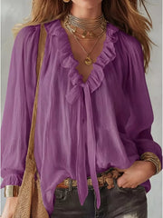 Purple frilled tie-front shirt with long sleeves and ruffled neckline.