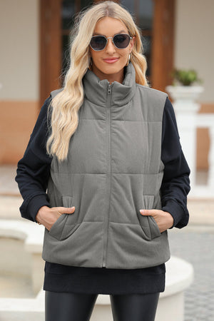 Padded corduroy funnel neck vest in Dust Storm with zip front and pockets.