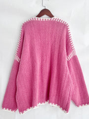 Pink oversized knit cardigan with contrast white stitching detail on neckline, cuffs, and hem.
