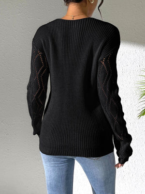 Black acrylic knit sweater with openwork diamond pattern on sleeves.