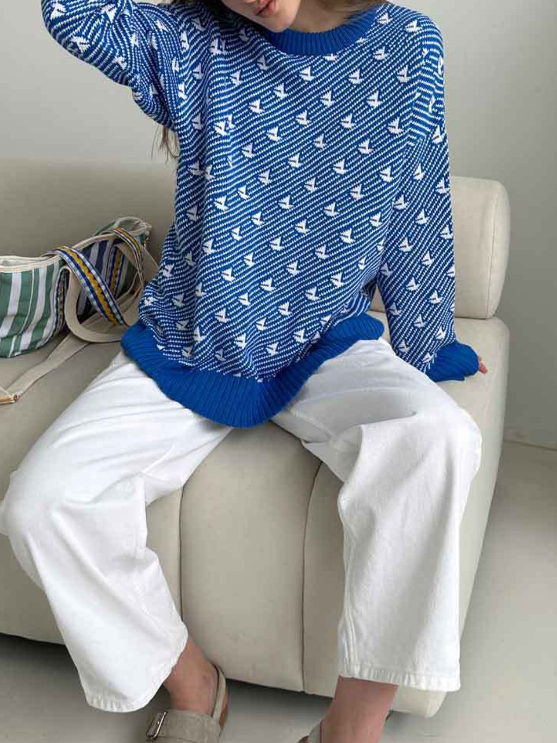 Royal blue knit sweater with allover white sailboat pattern and crewneck.