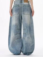 Men's light wash denim wide leg jeans with exaggerated balloon fit and stitched detailing.