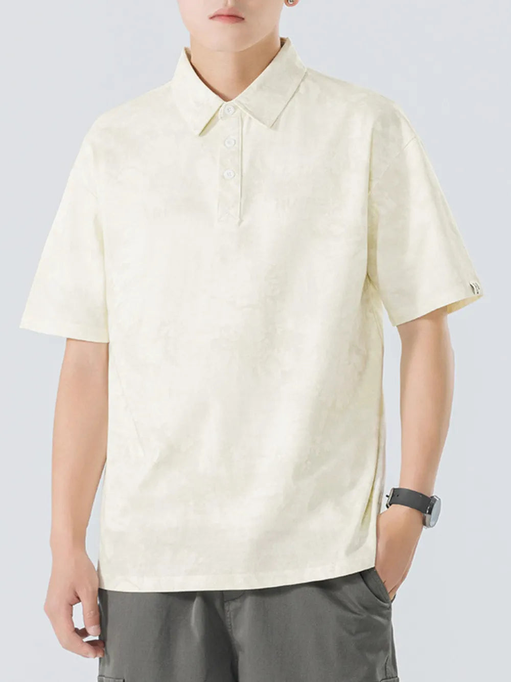 Cream cotton polo shirt with subtle texture and buttoned placket.