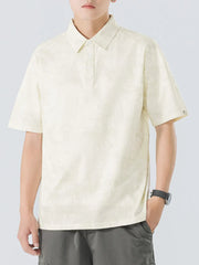 Cream cotton polo shirt with subtle texture and buttoned placket.