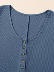 Dusty blue waffle knit button-down romper with a V-neck and wooden buttons.