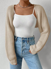 Khaki knit bolero shrug with long sleeves, styled over a white tank top and jeans.