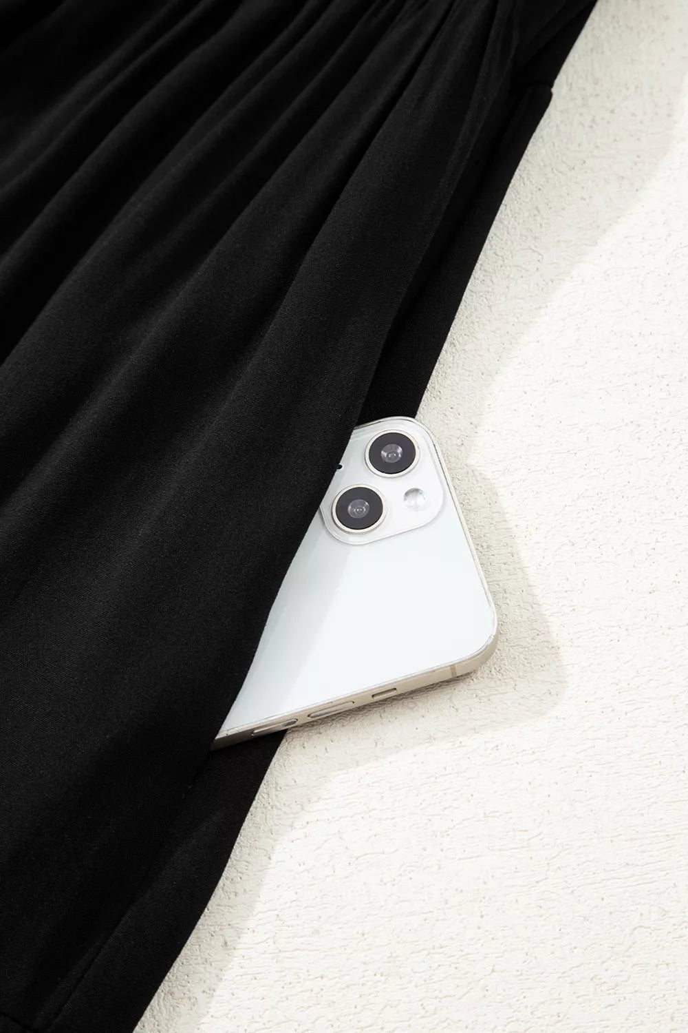 Black tiered maxi dress with hidden side pocket holding a smartphone.