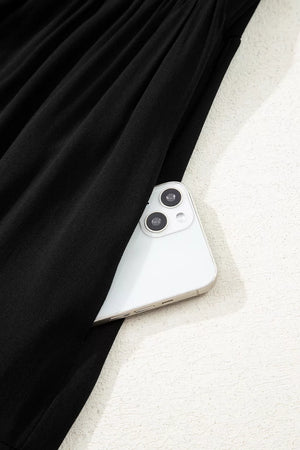 Black tiered maxi dress with hidden side pocket holding a smartphone.