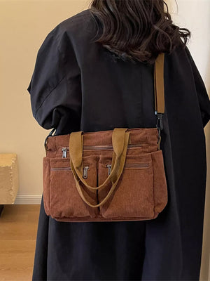 Brown corduroy crossbody bag with multiple zippered pockets and dual top handles.