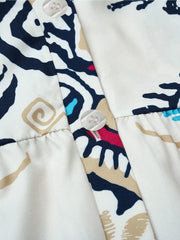 Vibrant abstract print mini dress with button detail and collared neckline.