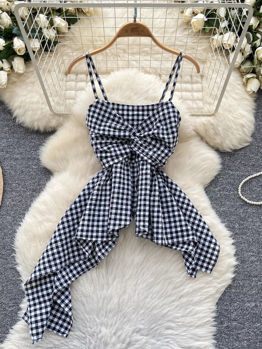 Black and white gingham cami top with a twisted knot front and asymmetrical hem.