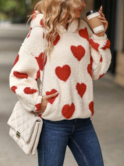 Cream sherpa hoodie with red heart print and front pocket detail.