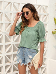 Sage off-shoulder ruffled sleeve top with smocked neckline and cuffs.