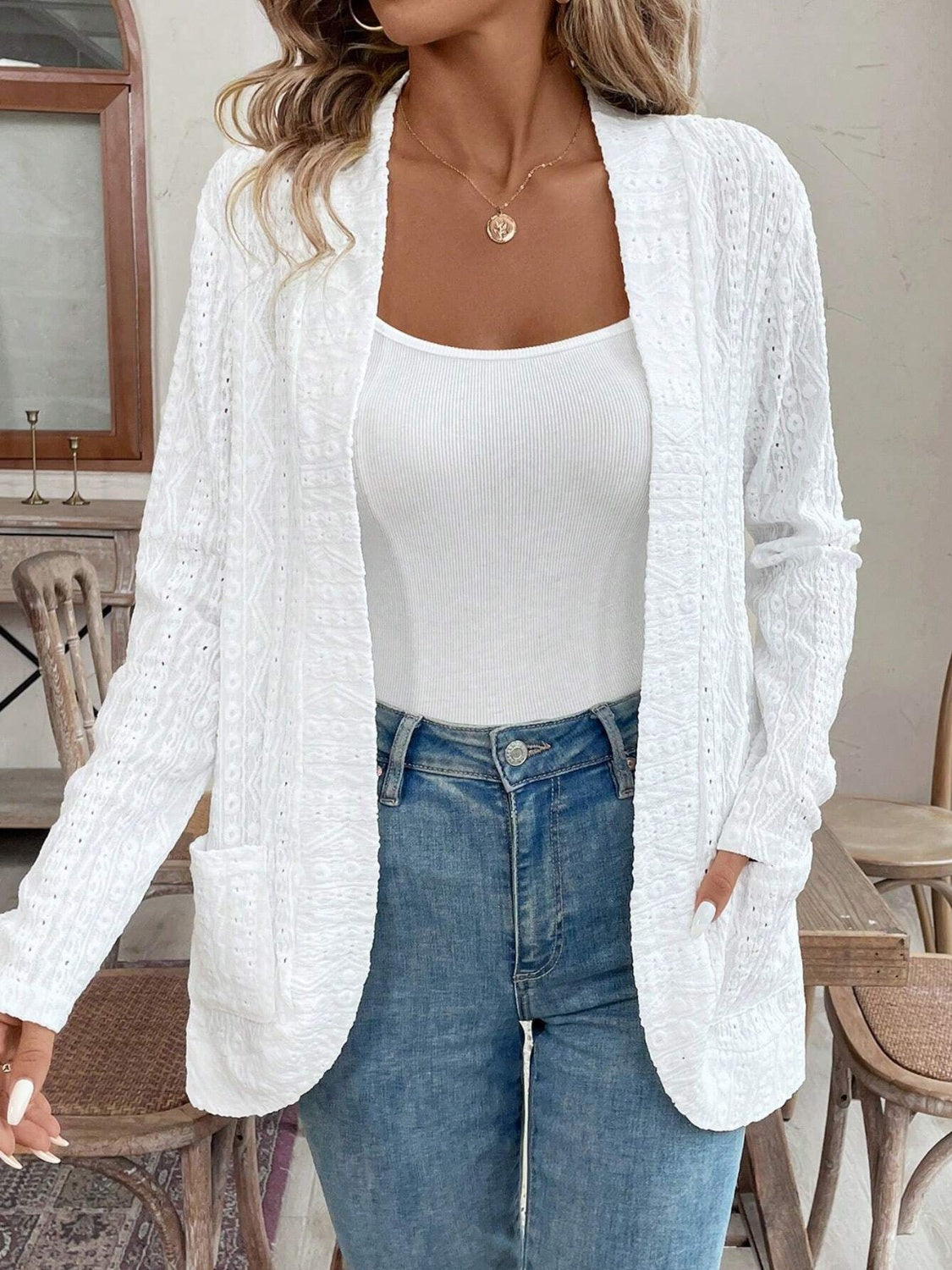 White open-weave embroidered cardigan with pockets, open front, and long sleeves.