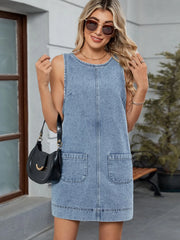 Sleeveless light blue denim pinafore dress with front pockets and a rounded neckline.