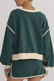 Dark green sweatshirt and skort set with cream contrast trim and neckline.