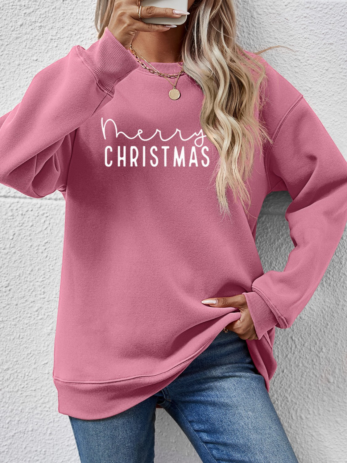 Blush pink sweatshirt with white Merry Christmas graphic, crewneck, long sleeves.
