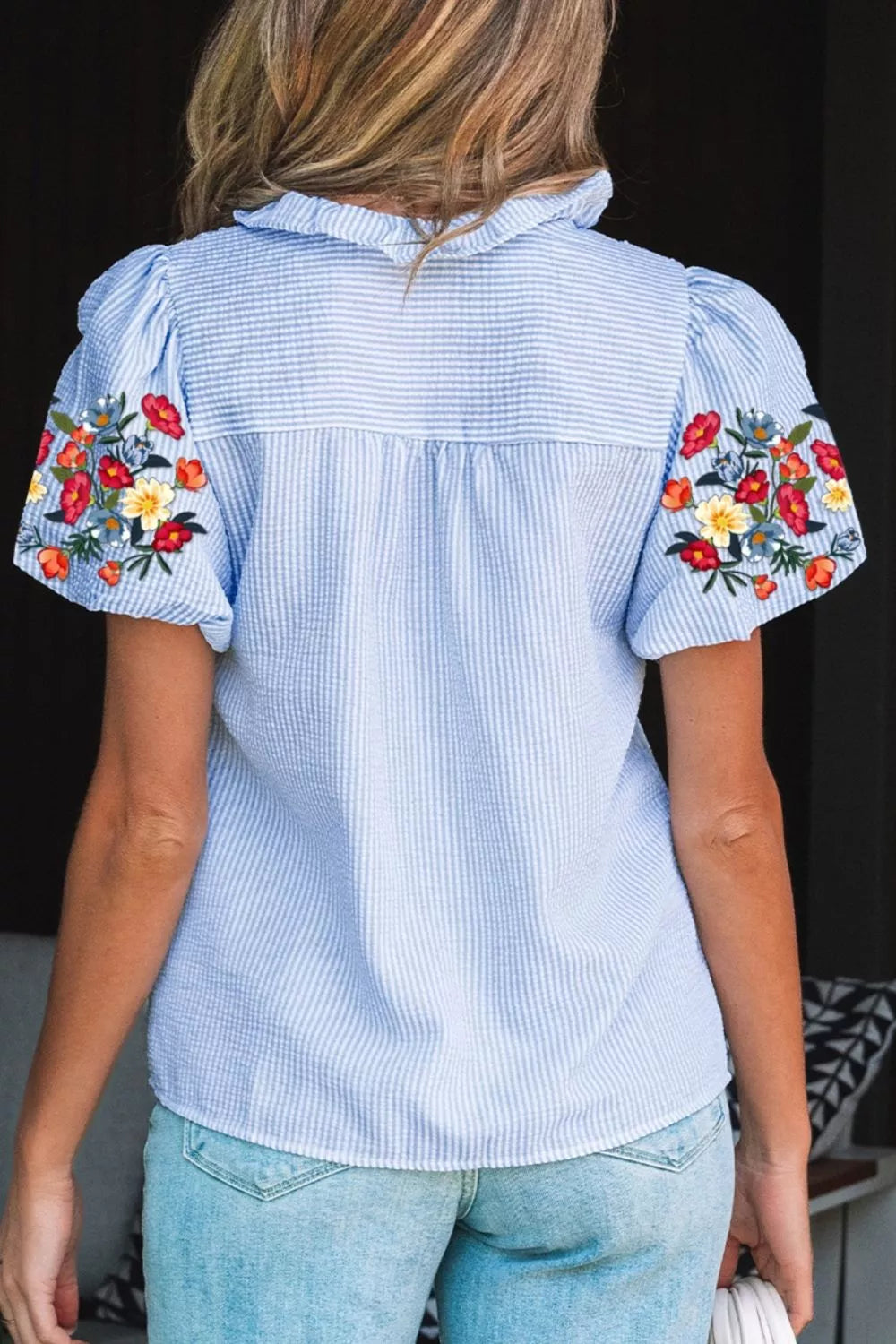 Blue striped cotton shirt with embroidered floral puff sleeves and ruffled collar.