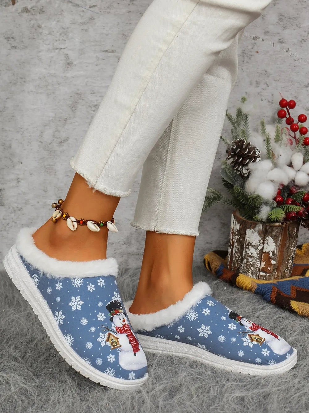 Blue snowman print sherpa lined holiday slides with snowflake pattern.