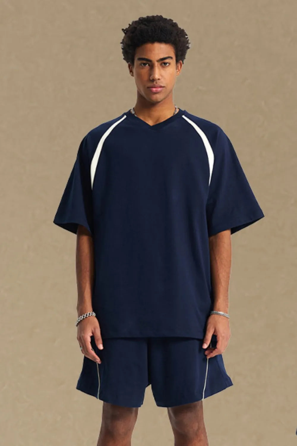 Navy V-neck raglan tee with white contrast trim on sleeves and neckline.
