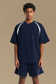Navy V-neck raglan tee with white contrast trim on sleeves and neckline.